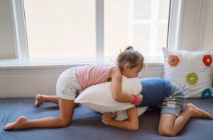 boy-and-girl-roughhousing-with-a-pillow