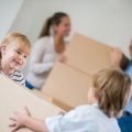 two kids showing acts of kindness to parents moving boxes