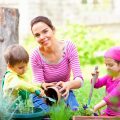 mom gardening with two kids