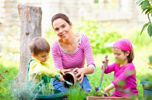 mom gardening with two kids