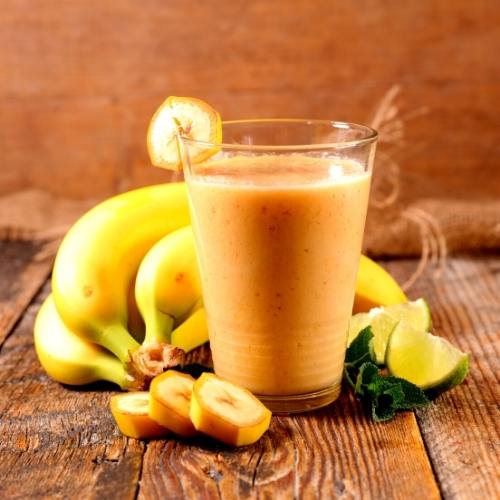 a glass of smoothie and three whole ripe banana