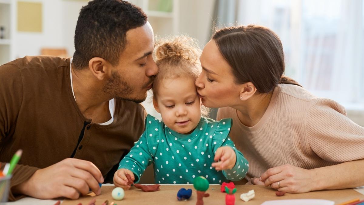 parents kissing their child to show love and avoid child depression
