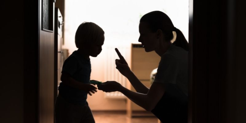 mother enforcing rules to a child in a dark room