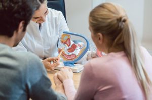 Doctor in fertility clinic counseling couple - Ways to pay fertility treatments