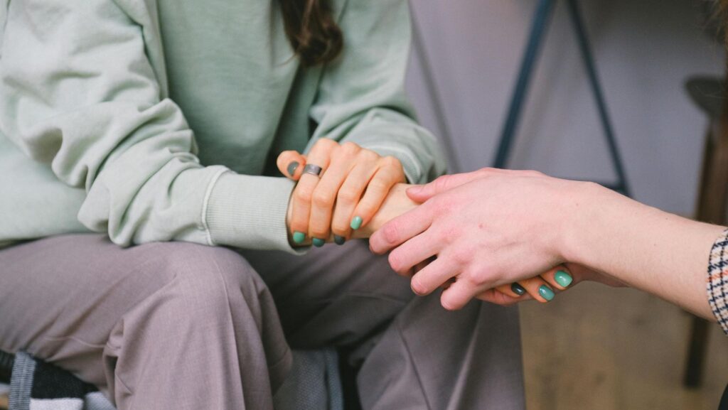 A person holding a girl's hand.